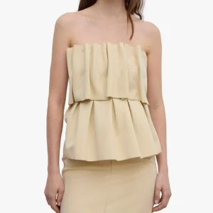 Beige volang tubtopp från Dagmar - Superfin beige tubtopp från Dagmar Vallgatan 12 med dubbla volanger och snyggt strukturerad passform. 