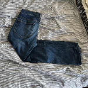 Mörkblå jeans från Acne Studios - Snygga mörkblå jeans från Acne Studios med klassisk femficksdesign och raka ben. Storlek W30 L32. Jeansen har subtila slitningar och kontrastsömmar, vilket ger en stilren och modern look. Perfekta för dig som gillar enkel och tidlös stil.
