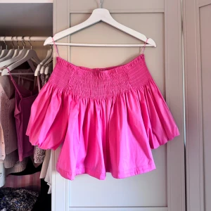 Rosa volangig blus från Zara - Intressekoll på denna supersöt rosa blus från Zara med smockad överdel och tunna axelband. Toppen har en volangig, luftig passform.