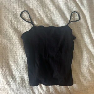 Svart ribbad linnetopp Kappahl - En svart ribbad linnetopp från Kappahl med smala axelband. 