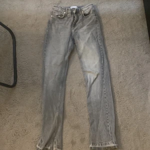 Jeans - Ett par gråa jeans med raka ben men är lite öppet vid fötterna