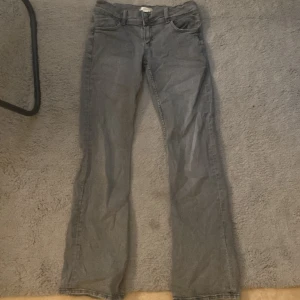 Jeans - Ett par gråa jeans med en stjärna där bak på ena fickan