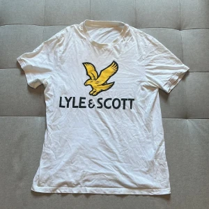 Vit Lyle & Scott t-shirt med tryck - Vit t-shirt från Lyle & Scott i mycket bra skick. Priset är ej hugget i sten! Tveka inte att skriva vid funderingar🤝