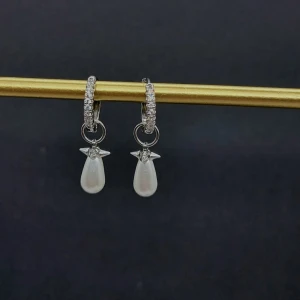 Glittriga örhängen med pärldroppar - Snygga örhängen i silverfärg med glittriga stenar på ringen och hängande droppformade vita pärlor. Perfekt accessoar för att lyfta din stil med en elegant touch. Klassisk design med modern vibe.