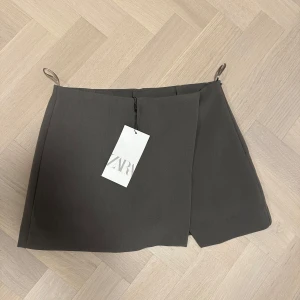 Mörkgrå omlottkjol från Zara - Stilren mörkgrå kortkjol från Zara med omlottdesign💗 ny med lappen kvar!