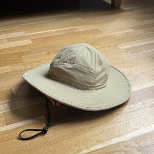 Patagonia Quandary Brimmer Beige/Sand Hatt - Patagonia hatt i modellen Quandary Brimmer och färgen Beige/Sand med reflex logga fram. OBS! Finns ett namn skrivet på etiketten! Storlek: L