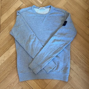 Stone island tröja - Säljer en klassisk Stone Island Sweatshirt. Tröjan är använd men har hållt ett mycket bra skick, inga fläckar eller slitage. Finns även i blå färg om ni hellre vill ha det. Äktheten kan ni själva testa genom att skanna QR koden på sista bilden. Pris kan självklart förhandlas!
