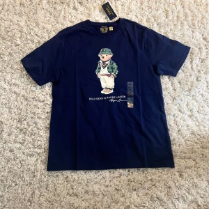 Mörkblå Polo Bear t-shirt Ralph Lauren - Snygg mörkblå polo Ralph T-shirt helt oanvänd råkade köpa en storlekar för stort har påsen den kom i. Helt ny skick storlek XL pris kan förhandlas privat