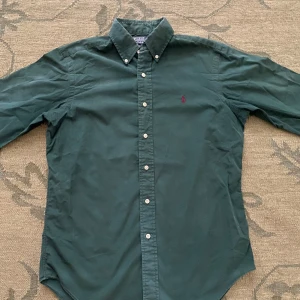 Grön skjorta från Polo Ralph Lauren - Mörkgrön skjorta från Polo Ralph Lauren i klassisk passform. Nypris: 1700kr