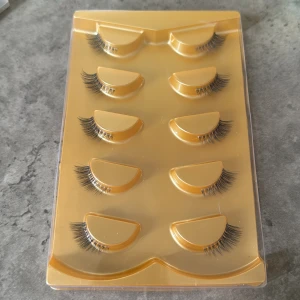 Svarta lösögonfransar i 5-pack - Säljer ett set med fem par svarta lösögonfransar i en guldfärgad förpackning. Fransarna är täta och har en naturlig böj för en snygg och markerad look. Perfekta för att lyfta din sminkning och ge extra volym till fransarna.