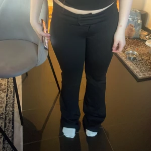 Svarta bootcut lågmidjade kostymbyxor - Snygga svarta kostymbyxor med bootcut-snitt och lågmidjade. Byxorna har en klassisk look med knapp och dragkedja framtill. Perfekta för dig som gillar en stilren och trendig vibe. Materialet känns mjukt och följsamt. Tryck ej köp nu❤️