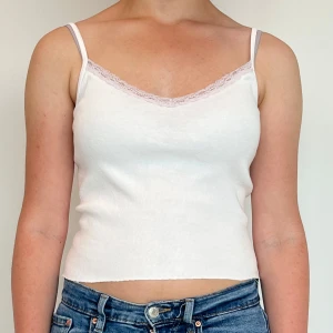 Vit linnetopp från Brandy Melville - Supersöt vit linnetopp från Brandy Melville💕Passar att ha den på vardagen eller som pyjamas! Storleken ör ONE SIZE. Spetsen är lite lila men det går nog bort sen lite i tvätten :)