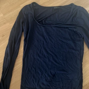 Mörkblå långärmad topp Gina Tricot - Snygg mörkblå långärmad topp från Gina Tricot i mjukt och stretchigt material. Enkel och stilren design med rund halsringning, perfekt att matcha med jeans eller kjol. Passformen är normal och toppen är superbekväm för alla tillfällen.