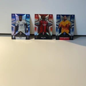 Stadium Star Limited Edition 23/24 Fotbollskort  - Säljer tre Stadium Star Limited Edition-kort från Topps! Exklusiva fotbollskort med stjärnor som Vini Jr., Rafael Leão och Gianluigi Donnarumma. Perfekt för unga fans och samlare som älskar fotboll och vill ha något unikt i sin samling.