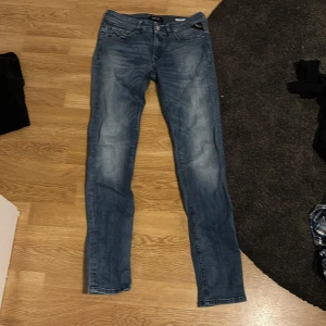 Blå Replay jeans LUZ, midja 27/30 - Snygga blå jeans från Replay, modell LUZ, i storlek 27/30. Jeansen har en klassisk femficksdesign, smal passform och lätt slitna detaljer för en cool look. Tillverkade i stretchig bomull för extra komfort.