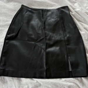 Svart skinnkjol från BikBok - Svart kort skinnkjol från Bikbok i storlek 36. Köpte kjolen i somras för 399kr men sen dess har den bara legat i garderoben och aldrig använts. Så jag hoppas den får bättre användning hos nån annan! Säljer den nu för 199kr! Skriv om du har nån fundering 🌸