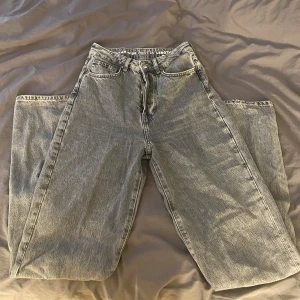 Gråa wide jeans med hög midja - Säljer ett par gråa jeans med breda ben och hög midja. Klassisk femficksmodell med knappar istället för dragkedja.