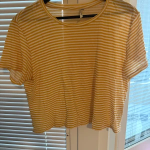 Gul- och vitrandig topp från Monki - Superfin gul- och vitrandig topp från Monki med korta ärmar och rund hals i storlek M.