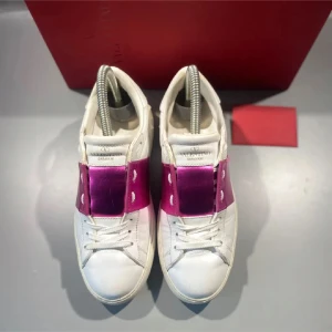 Valentino Garavani sneakers med rosa detalj - Snygga vita sneakers från Valentino Garavani med en metallicrosa panel över snörningen. Skorna har rund tå, platt sula och klassisk snörning. Perfekt för dig som vill sticka ut med en cool färgdetalj. Tillverkade i skinn med exklusiv känsla.