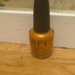 Guldig nagellack från OPI - Snyggt nagellack från OPI i en glittrig guldig nyans. Kommer i klassisk OPI-flaska med svart kork och glasbehållare. Perfekt för dig som vill ha extra bling på naglarna.