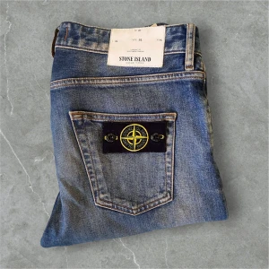 Stone Island blå jeans - Snygga blå jeans från Stone Island i modellen ”SL” som ej tillverkas längre, med klassisk femficksdesign och ikonisk patch på bakfickan. Jeansen har raka ben och en något tvättad look som ger en cool vibe. Tillverkade i slitstarkt denim med detaljerade sömmar och knappgylf. W:30 L:34! Nypris: ca 3500 ( Säljs inte längre) Mittpris: 799 kr💯 ‼️KOMMER ENDAST VISA CERTILOGON FÖR SERIÖSA KÖPARE‼️ Kan gå ner i pris vid snabb köp‼️