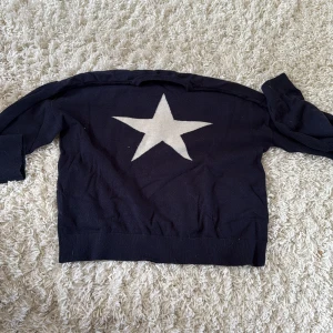 Mörkblå  stickad tröja med stjärna Gina Tricot -  tröja från Gina Tricot med en stor vit stjärna på framsidan. Tröjan har rund halsringning och långa ärmar. Perfekt för dig som gillar en enkel men ändå cool look med en tydlig detalj framtill. Pris kan diskuteras!