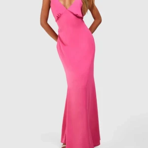 Rosa långklänning med djup rygg - Snygg rosa långklänning från Boohoi i vävd polyester med djup v-ringning fram och draperad öppen rygg. Klänningen har en figurnära passform och slits baktill för extra rörelsefrihet. Den är i storlek 8 alltså 36, helt ny och oanvänd med prislapp, köpt för 700kr och säljer den för 299kr
