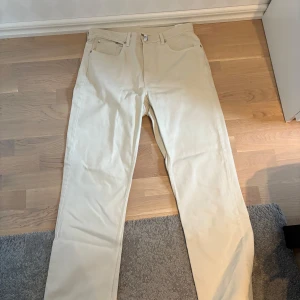 Beige straight jeans från Weekday - Snygga beige jeans från Weekday i modellen Voyage High Straight. Byxorna har en liten hög midja och raka ben, och är gjord av bomull. Perfekta för en clean och stilren look!
