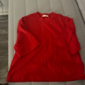 Röd basic t-shirt med loose fit - Enkel röd t-shirt med rund hals och korta ärmar. Modellen är loose fit och passar perfekt för en avslappnad stil. T-shirten är helfärgad utan tryck eller mönster och är tillverkad i mjuk bomull.