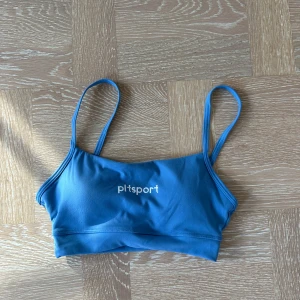 Blå linnetopp från PLT Sport - Snygg blå linnetopp från PLT Sport med tunna axelband och sportig vibe. Perfekt för dig som gillar en enkel och stilren look när du tränar eller chillar. Mjuk och stretchig syntet som sitter skönt på kroppen.