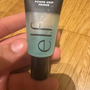 e.l.f. Power Grip Primer 15ml - Säljer en e.l.f. Power Grip Primer i en smidig tub på 15 ml. Primern är genomskinlig med en lätt blågrön ton och har svart lock. Perfekt för att få sminket att sitta hela dagen och ge en jämn bas. Enkel att applicera med fingrarna.