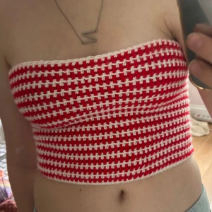 Röd och vit virkad tubtopp med snörning - Handvirkad tubtopp i rött och vitt med randigt mönster. Toppen är bandeau-modell och har snygg snörning i ryggen som gör att du kan justera passformen. Skriv om du har någon fråga!💗