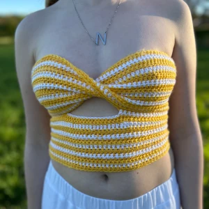 Gul och vit virkad bandeau tubtopp - Superfin handvirkad bandeau tubtopp i gult och vitt med randigt mönster. Toppen har twistad front, cutout under bysten och snörning i ryggen för perfekt passform. Skriv för frågor!💗