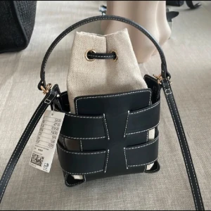 Svart och beige bucket bag med snörning - Väska från hm som är slutsåld. Fint skick och knappast andvänd! Bilderna är lånade 💖