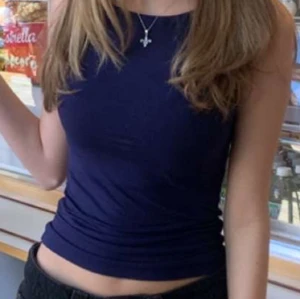 Mörkblå ärmlös topp från Nelly - Säljer en stilren mörkblå ärmlös topp från Nelly i storlek XXS. Toppen har en tight passform och är tillverkad i mjuk bomull. Perfekt att matcha med jeans eller kjol för en clean look.