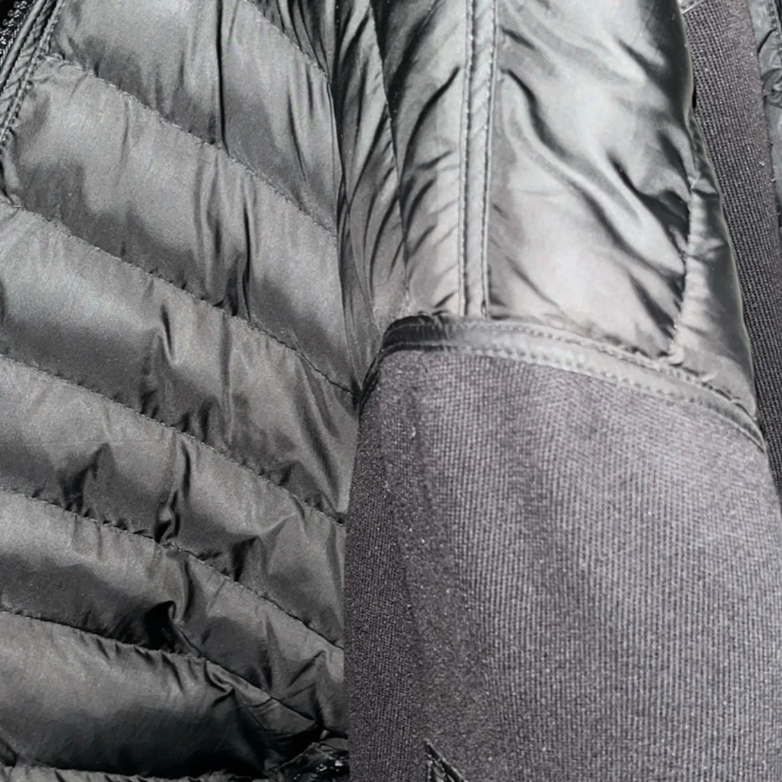 Svart pufferjacka med stickade partier