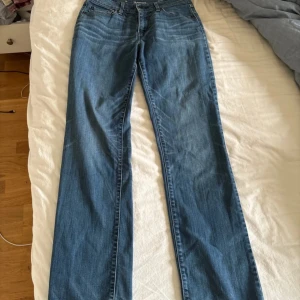 Blå Levis 501 jeans med raka ben - Klassiska blå Levis 501 jeans med raka ben och normal passform. Jeansen har fem fickor, knappgylf och tydliga Levis-detaljer på bakfickorna. Perfekta för en avslappnad och tidlös stil.