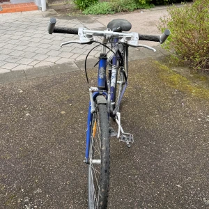 Blå och silverfärgad herrcykel från Cyclepro - Säljer en blå och silverfärgad herrcykel av modellen Crossroads från Cyclepro. Cykeln har raka styren, pakethållare bak, reflexer och handbromsar. Passar för dig som vill ha en robust cykel för vardagsbruk.