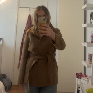 Beige kappa med bälte - Beige kappa med bälte i midjan. Storlkek 40 men passar på mig som har s.