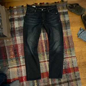 Mörkblå selvedge jeans från Kings of Indigo - Säljer ett par mörkblå jeansbyxor från Kings of Indigo, tillverkade av ekologisk bomull. Klassisk femficksmodell med raka ben och kontrastsömmar. Perfekta för dig som gillar stilrena och hållbara jeans.