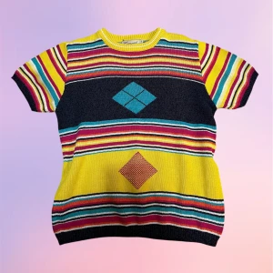 Retro topp - Ett coolt äkta retro plagg! 🌸  Vintage stickad kortärmad topp med färgglatt mönster. Häftig baksida på tröjan dessutom. Spekulerar att den är kanske från 70-talet? Men jag vet inte exakt.   Jättefin utan defekter, inga noppror heller! Storlek S från märket Ganard. Normal i storleken.  Vid frågor eller så är det bara att skriva!