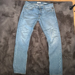 Ljusblå jeansbyxor från Replay(nya) - Säljer ett par klassiska ljusblå jeans från Replay med raka ben och fem fickor. Byxorna har normal passform och är tillverkade i jeansmaterial. Perfekta för en avslappnad stil. Dessa är helt nya, tog bort lapparna på dem och Carlings vägra låta mig lämna tillbaka dem. De satt lite tight på mig, använde dem en gång men säljer dem nu helt nya och helt otvättade. Skriv gjärna för frågor. (Modell grover, straight fit)