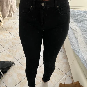 Svarta skinny jeans - Säljer ett par svarta skinny jeans med klassisk femficksdesign och medel midja. Jeansen har dragkedja och knapp framtill samt smal passform hela vägen ner. Perfekta för dig som gillar en tight och stilren look. Pris går att diskutera.