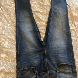 Blå skinny jeans från New yorker  - Säljer ett par blå skinny jeans från FSBN i storlek W34/L32. Klassisk femficksmodell med snygg tvätt och smal passform. Perfekta för dig som gillar en tajtare stil. Märke på bakfickan och läderpatch i midjan. Helt oanvända, kommer dock utan kvitto och prislapp