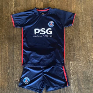 PSG kit - Säljer ett lite använt PSG kit utan namn och nummer. Den har storlek 10 i fotbollströjor så jag har testat och anser det som barnstorlek 134.
