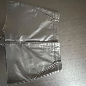 Svart shorts/kjol från Zara - Bundle rabatt finns!❤️Snygga svarta shorts som egentligen är en kjol i skinnimitation från Zara. De har normal passform, bälteshällor och klassisk design med fickor fram. Storlek S jättefint skick, passar s-m, kan sänka priset vid snabb affär!