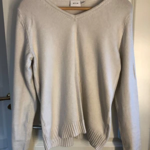 Vit stickad tröja  - Säljer en enkel och stilren vit stickad tröja från VILA i storlek s. Tröjan har v-ringad halsringning, långa ärmar och ribbade muddar vid ärmslut och nederkant 🤍