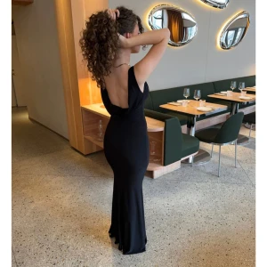 Svart långklänning  - Säljer denna otroligt fina långklänning ifrån design by si i st M. Den är aldrig använd och jag säljer den pga att den aldrig kommer till användning! Nypris är 575kr men säljer för 300!!