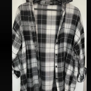 Svartvit rutig skjorta från Shein - Säljer en oversized svartvit rutig skjorta från Shein. Skjortan har långa ärmar, klassisk krage och knäppning framtill. Perfekt att bära öppen eller stängd för en avslappnad look.