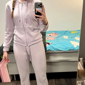 Ljuslila Gina Tricot mjukisset - Jättefint ljuslila set med mjukisbyxor och kofta från Gina Tricot! Rätt bra använt vilket runt på rumpan och vid armbågarna, några små skavanker (se bilder) men overall väldigt fina och mysiga. Storlek M i både byxor och kofta. Jag är 173 cm lång!